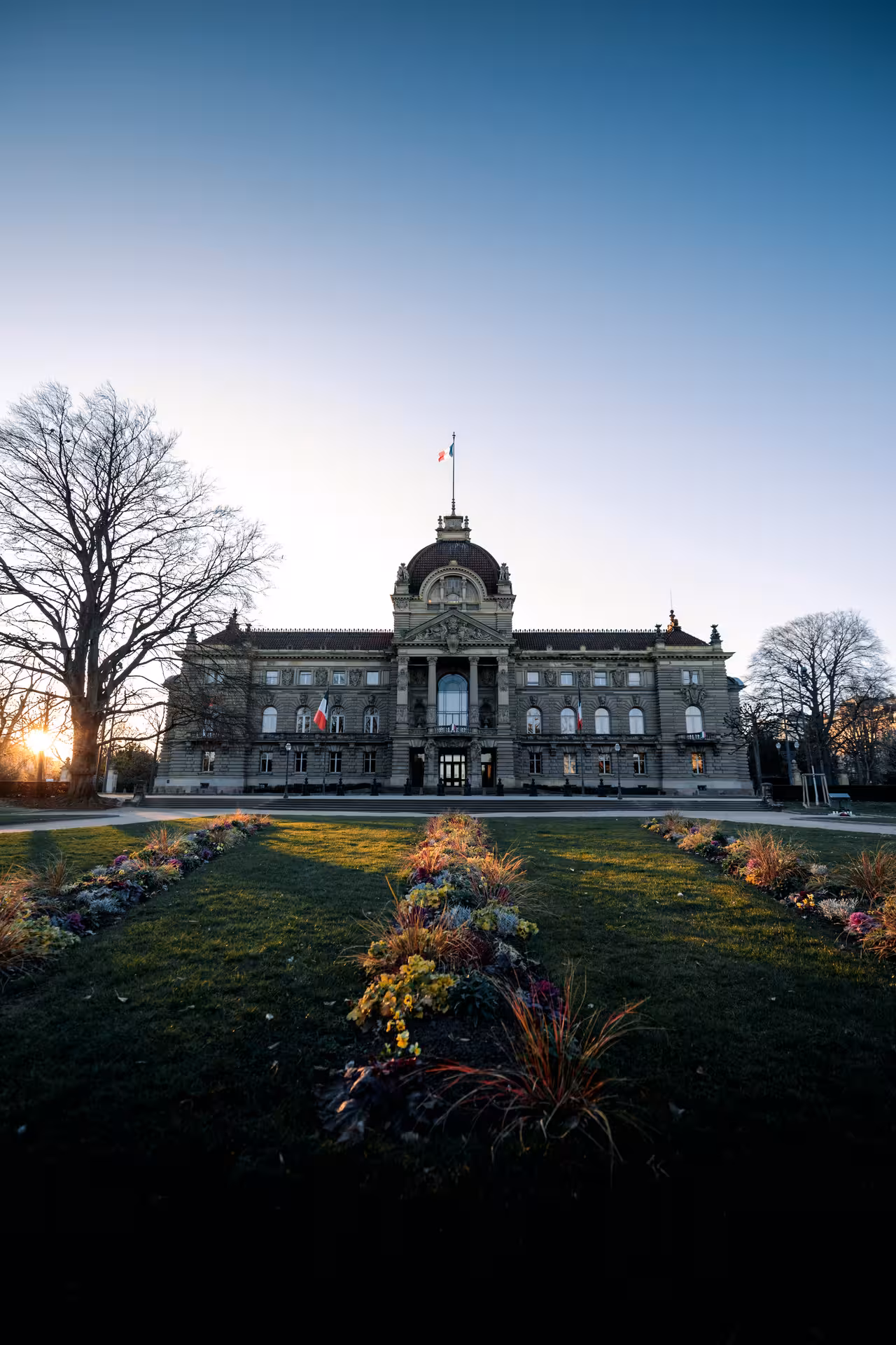 Ornate neoclassical Palais du Rhin in Strasbourg with manicured gardens at golden hour