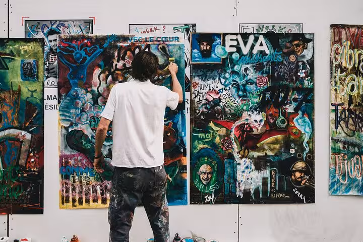 Street artist creating vibrant graffiti on a wall in Rome during the Art & Craft Beer Tour.