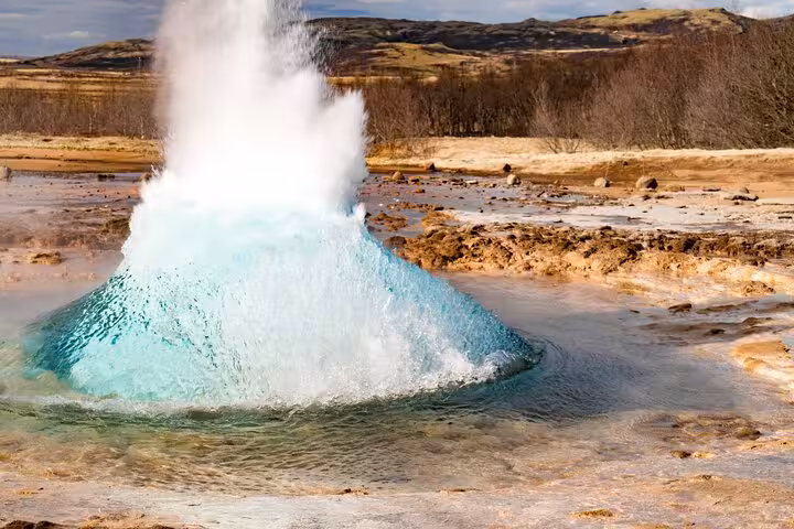 Strokkur geyser erupting with turquoise water bubble in Iceland's Golden Circle geothermal area