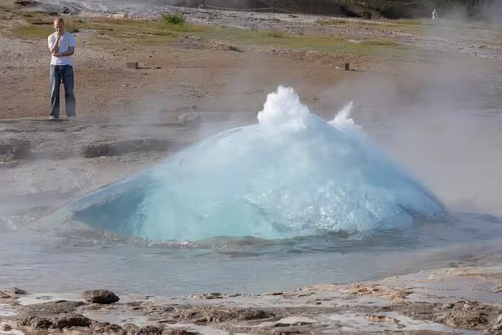 Strokkur geyser erupting with blue water dome on Iceland's Golden Circle route