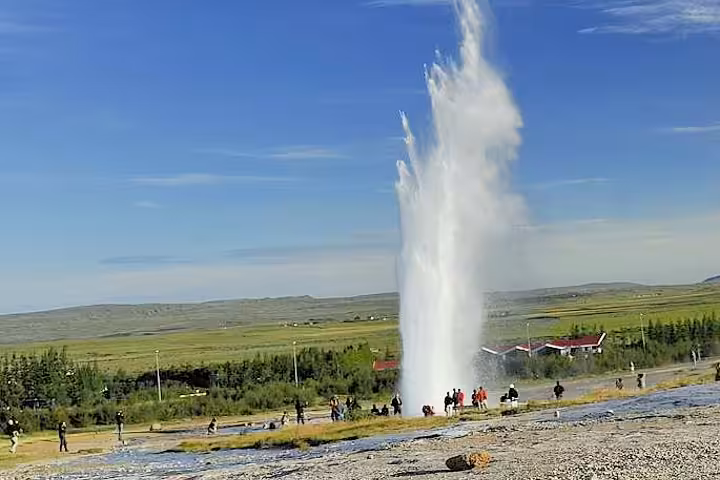 Strokkur geyser erupting on Iceland's Golden Circle with tourists watching nearby