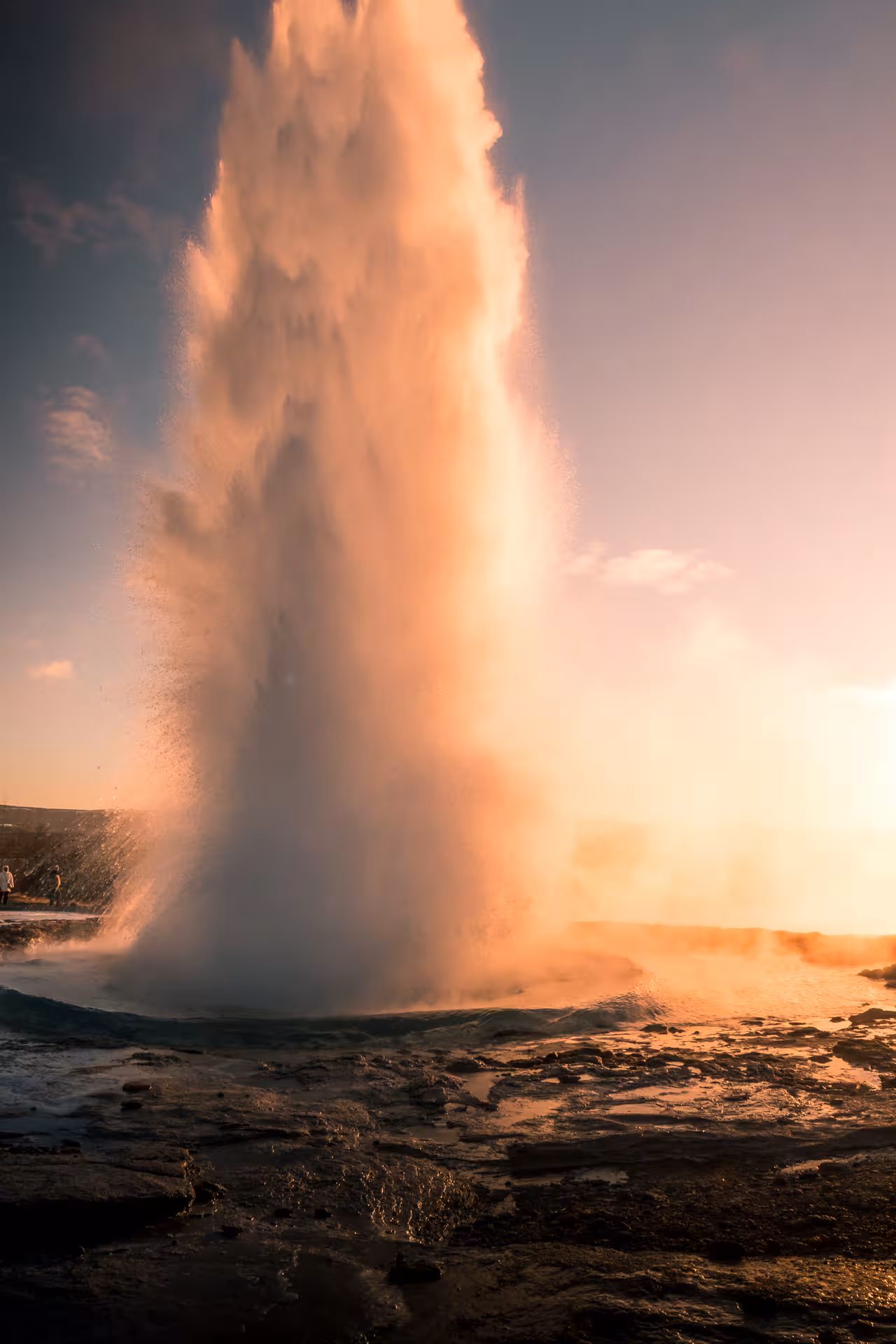 Strokkur geyser erupting at golden sunset on Iceland's Golden Circle route