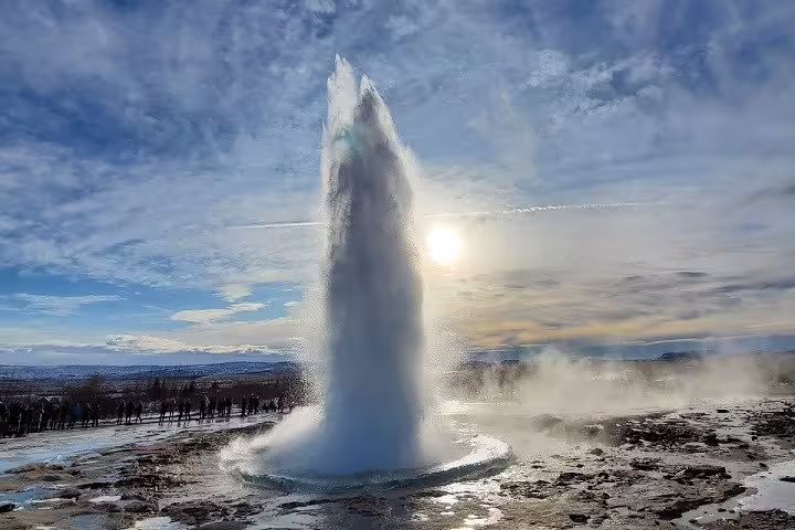 Strokkur geyser erupting dramatically against a cloudy sky on Iceland Golden Circle tour adventure