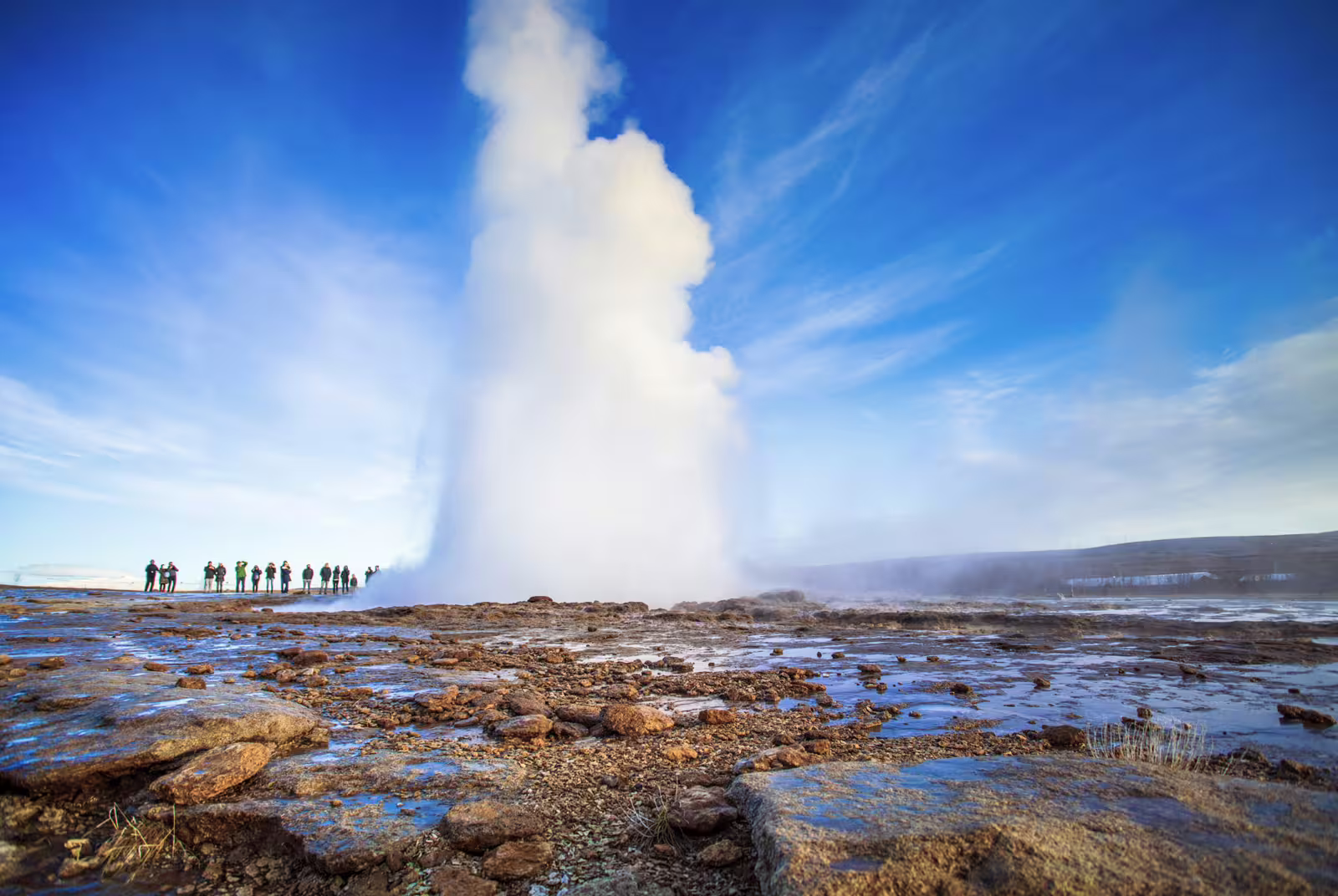 Strokkur geyser erupting on Iceland's Golden Circle with tourists watching nearby