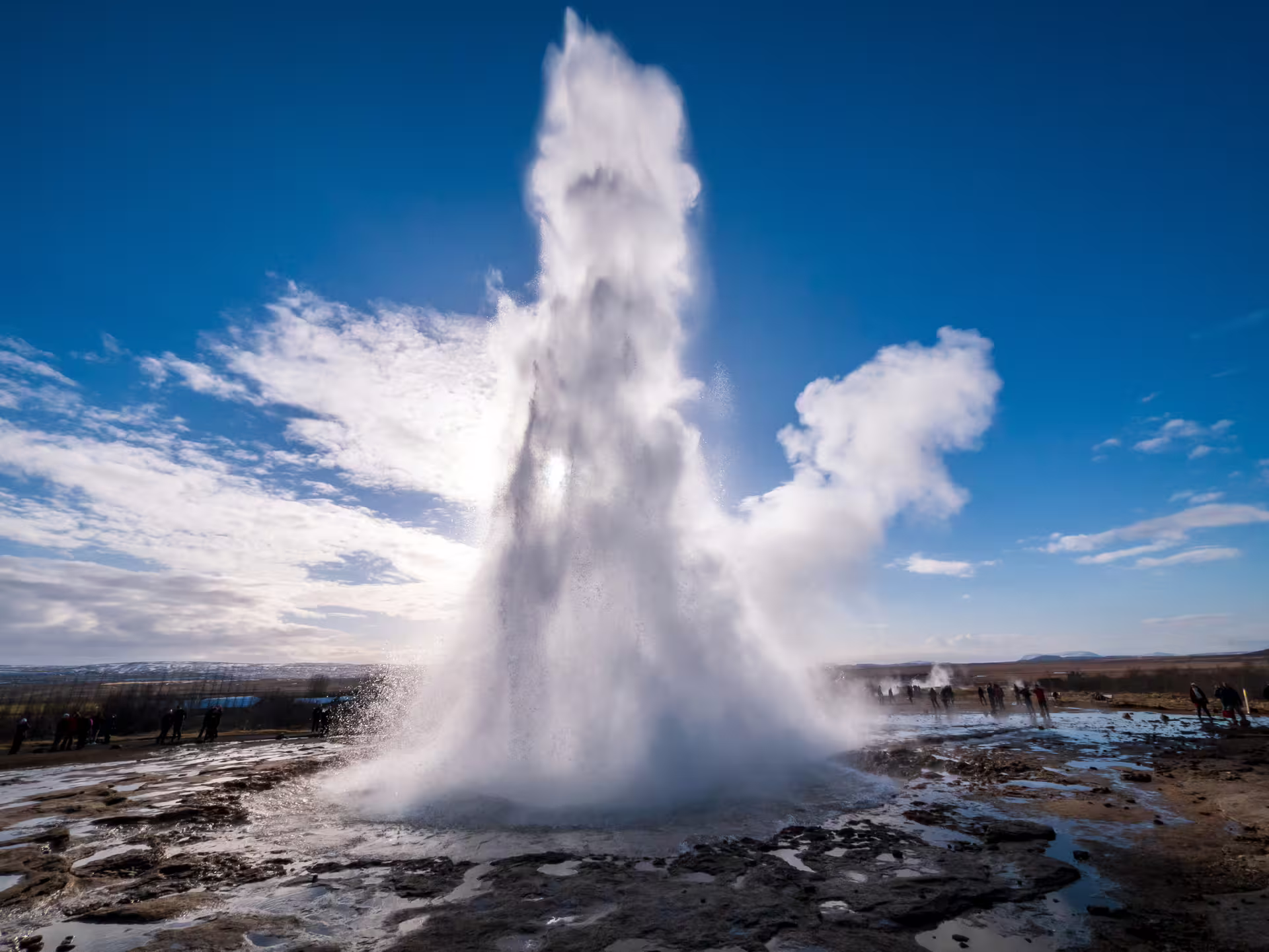 Strokkur geyser erupting on Iceland's Golden Circle with tourists watching nearby