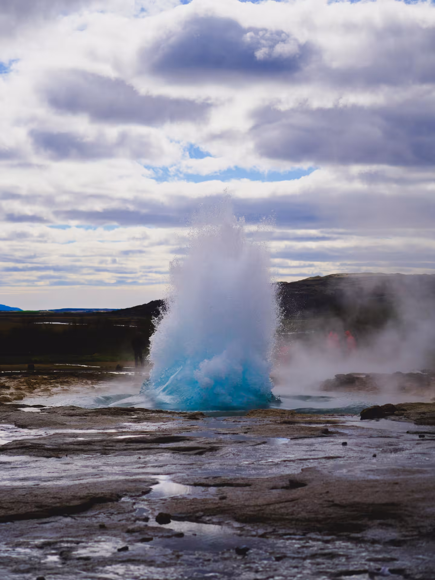 Strokkur geyser erupting with vivid blue water on Iceland's Golden Circle route