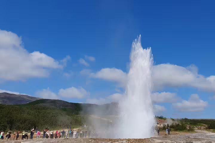 Strokkur geyser erupting on Iceland's Golden Circle with tourists watching nearby