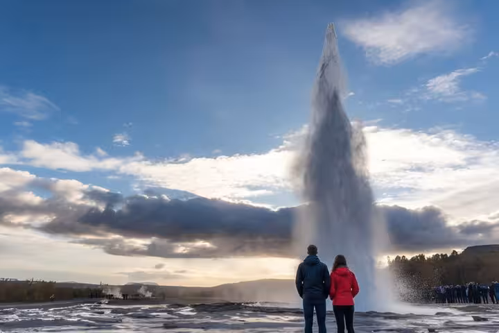 Couple watching Strokkur geyser eruption on Golden Circle tour in Iceland