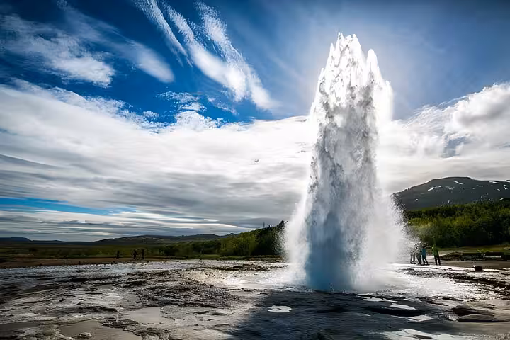 Strokkur geyser erupting on Iceland's Golden Circle with visitors watching nearby