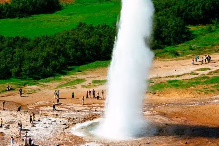 Strokkur geyser erupting on Iceland's Golden Circle with tourists watching nearby