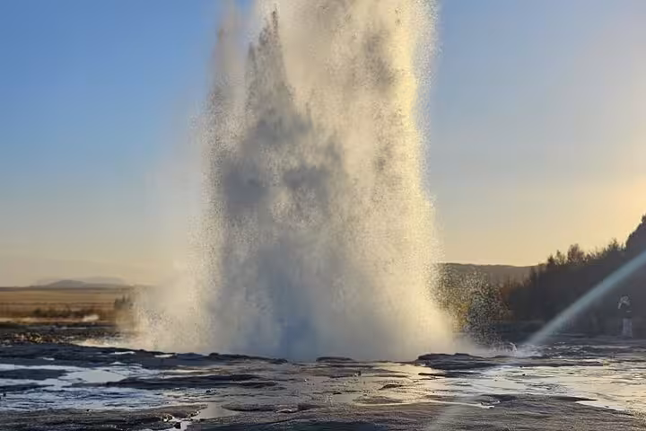 Strokkur geyser erupting on Iceland's Golden Circle route during golden hour