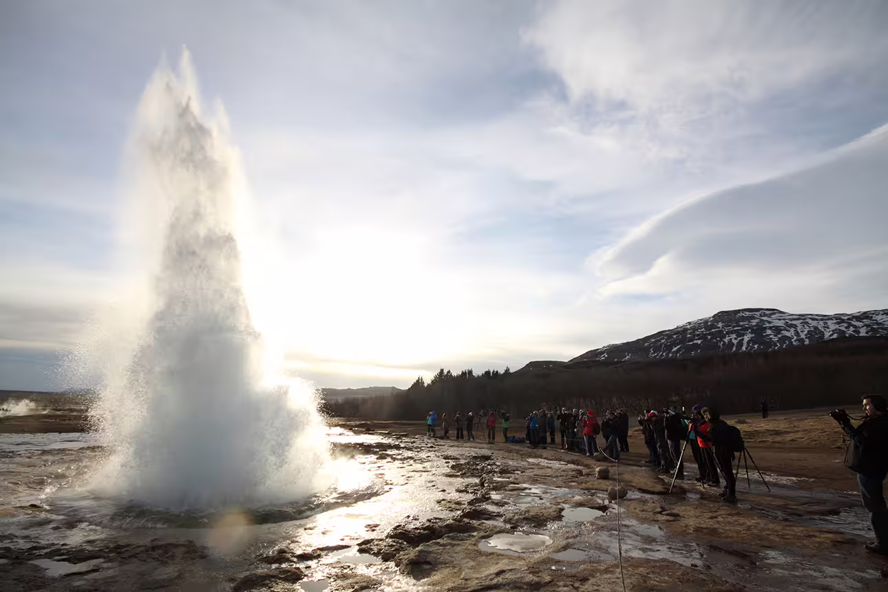 Strokkur geyser erupting with tourists watching at Golden Circle Iceland