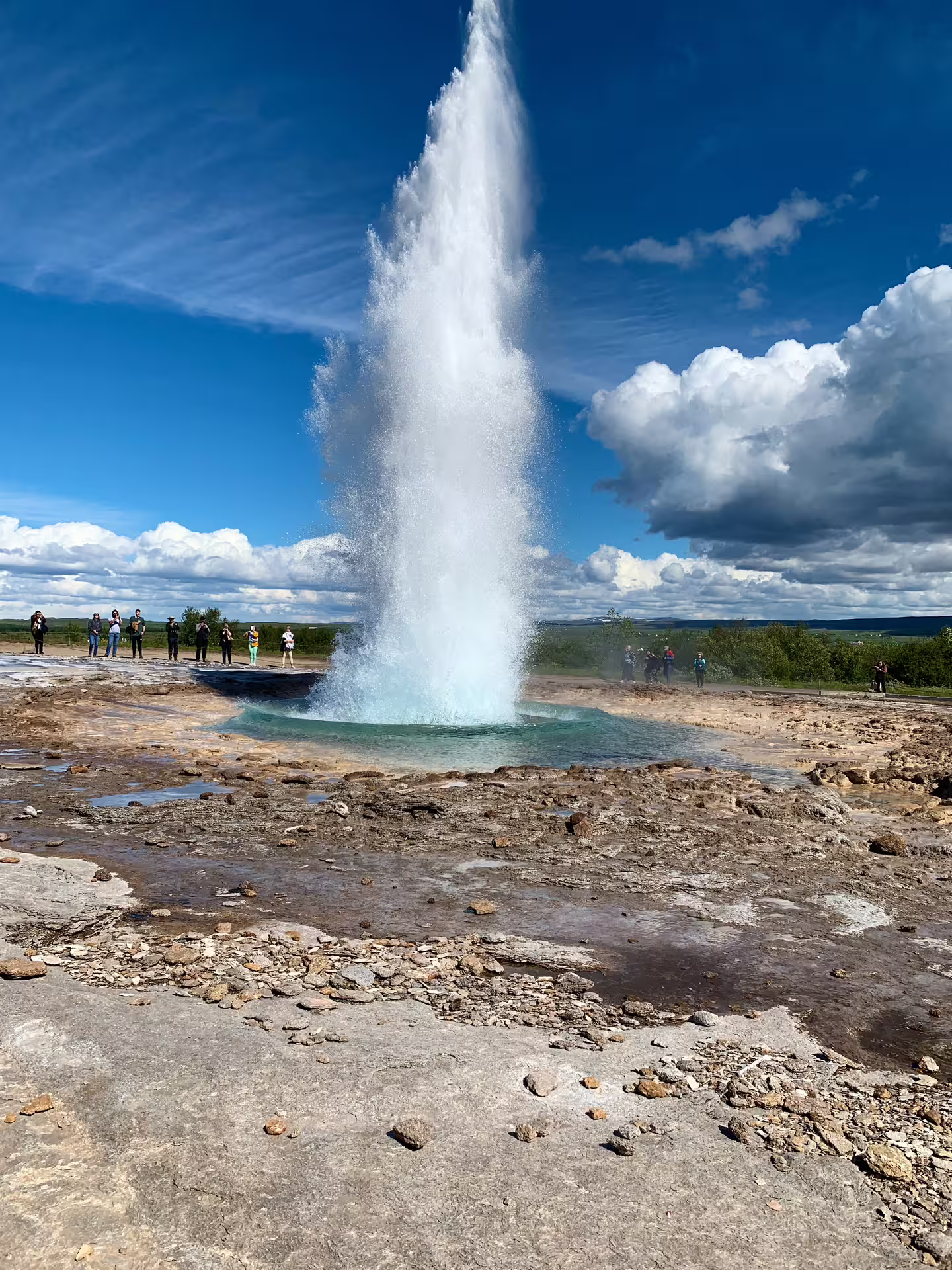 Strokkur geyser erupting on Iceland's Golden Circle with tourists watching nearby