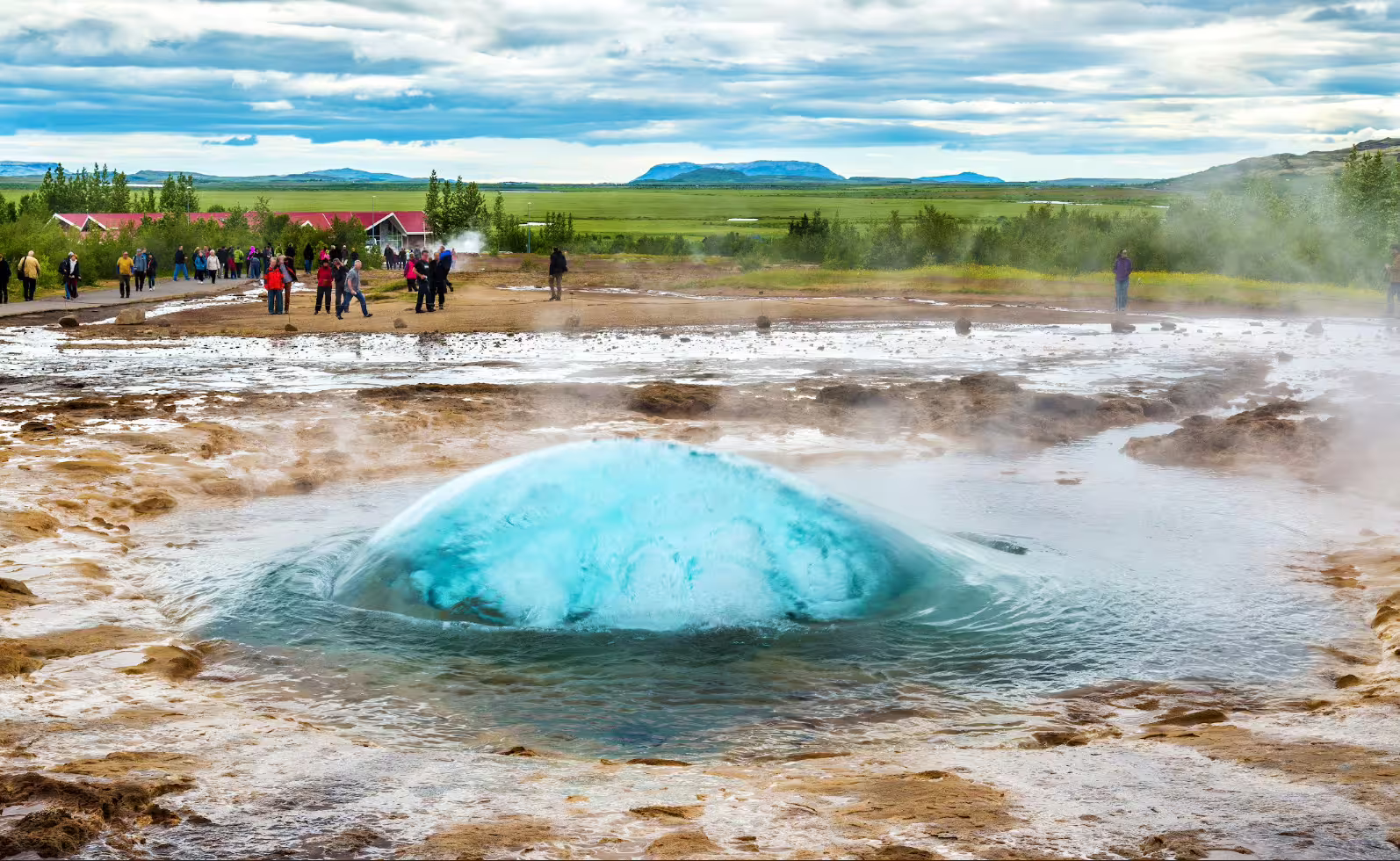 Strokkur geyser bubbling up with turquoise water dome before eruption at Golden Circle Iceland