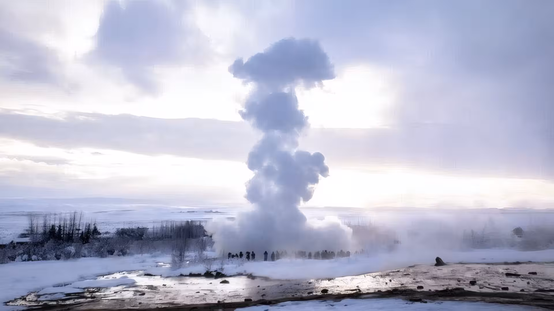 Strokkur geyser erupting steam column in snowy winter landscape, Golden Circle Iceland