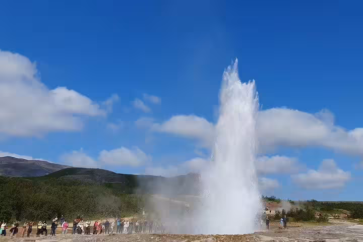 Strokkur geyser erupting on Iceland's Golden Circle with tourists watching nearby