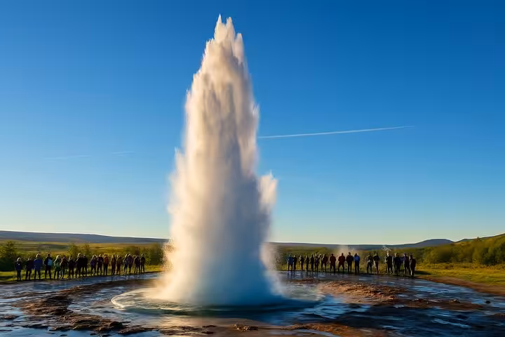 Strokkur geyser erupting on Iceland's Golden Circle with tourists watching from a safe distance