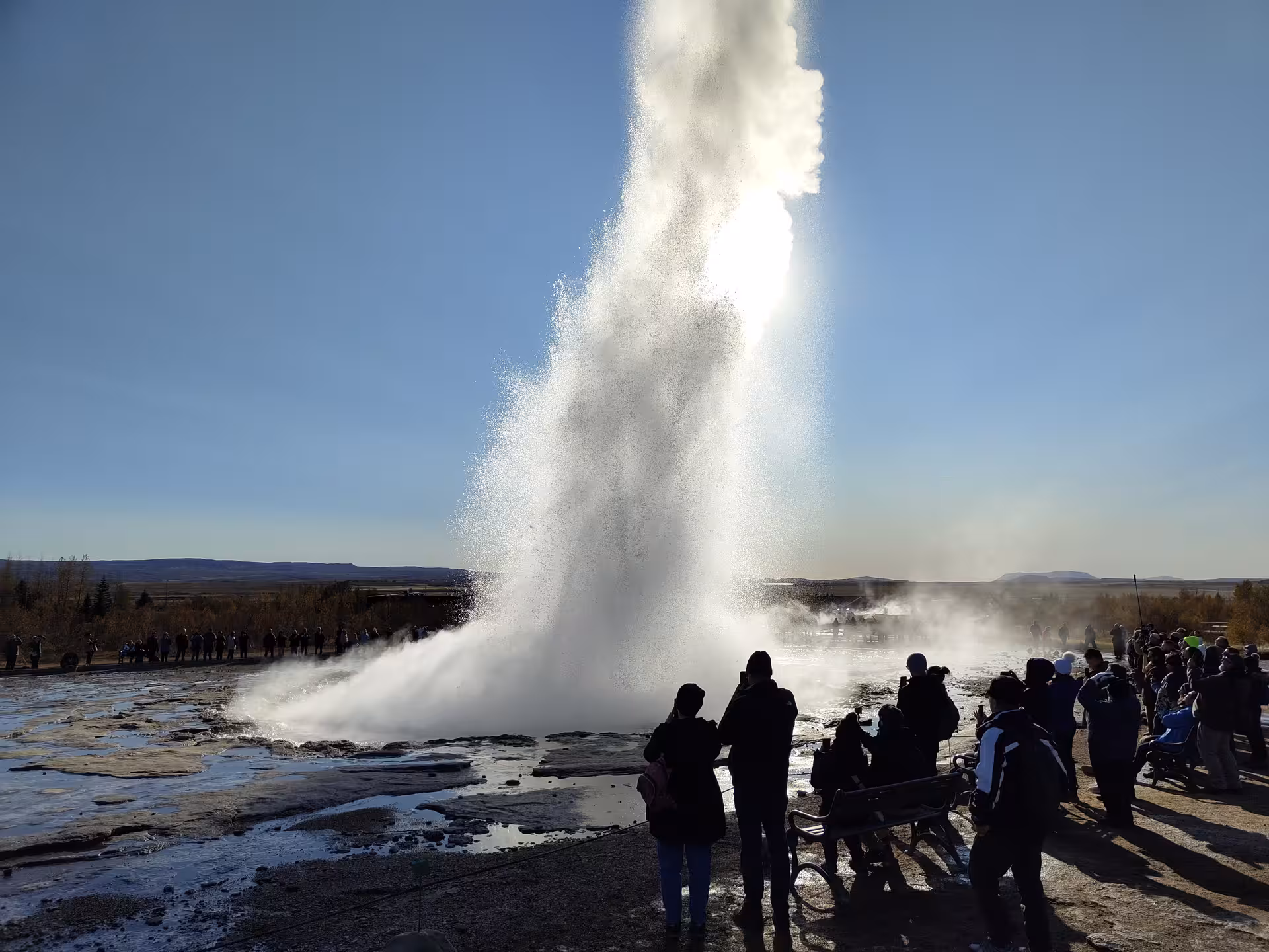 Strokkur geyser erupting on Iceland's Golden Circle with tourists watching the powerful water column