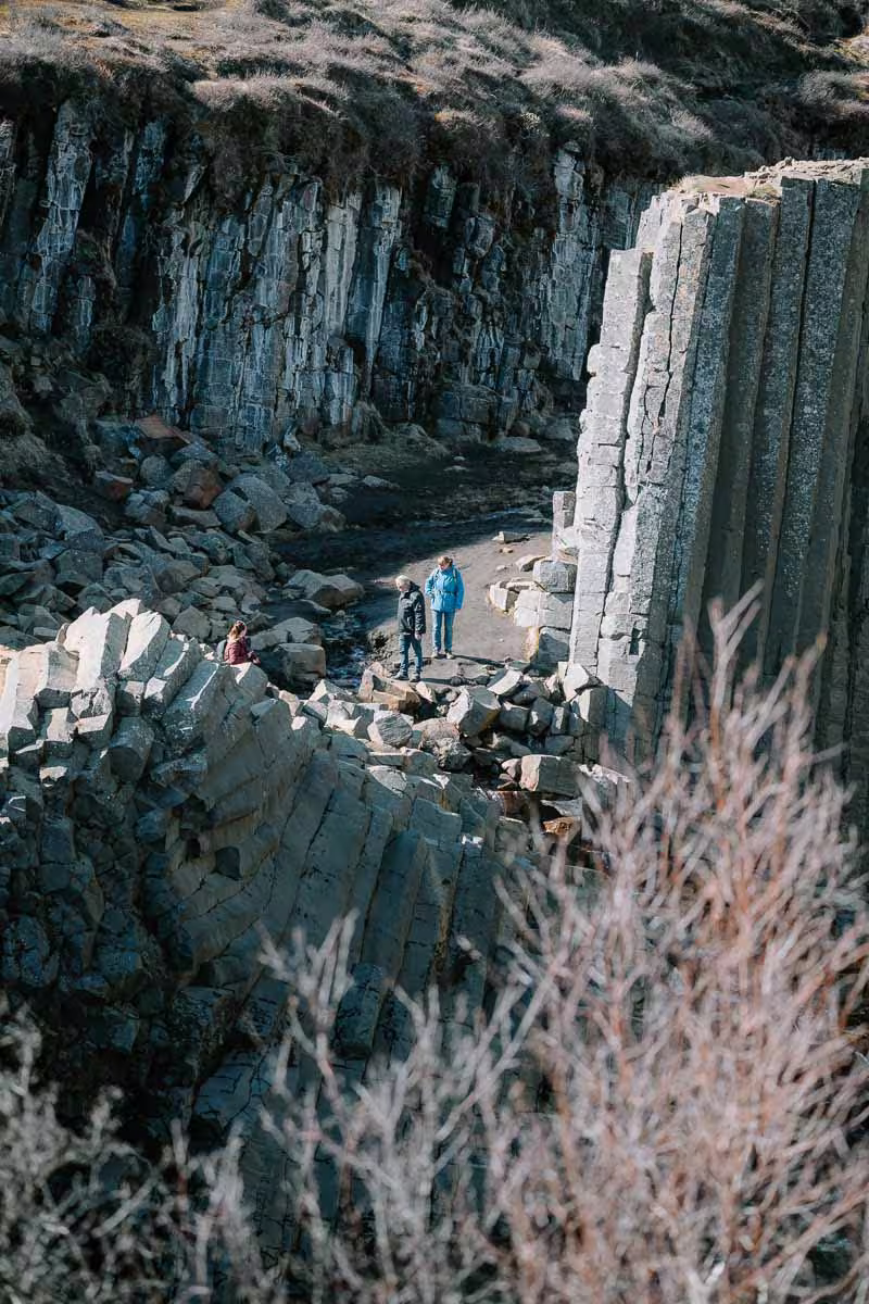 Visitors exploring Studlagil Canyon's dramatic basalt column formations in East Iceland