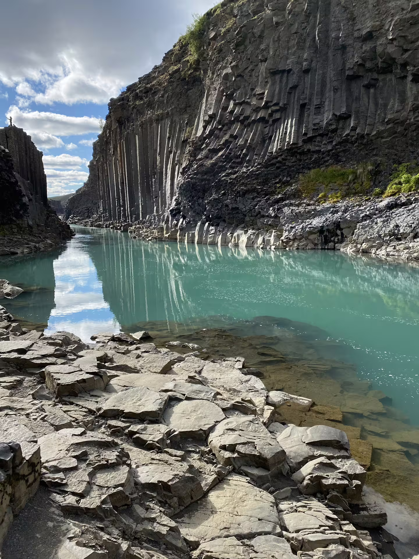 Stunning Stuðlagil Canyon featuring towering basalt columns and crystal-clear turquoise river visited on a Grand Tour of Iceland.