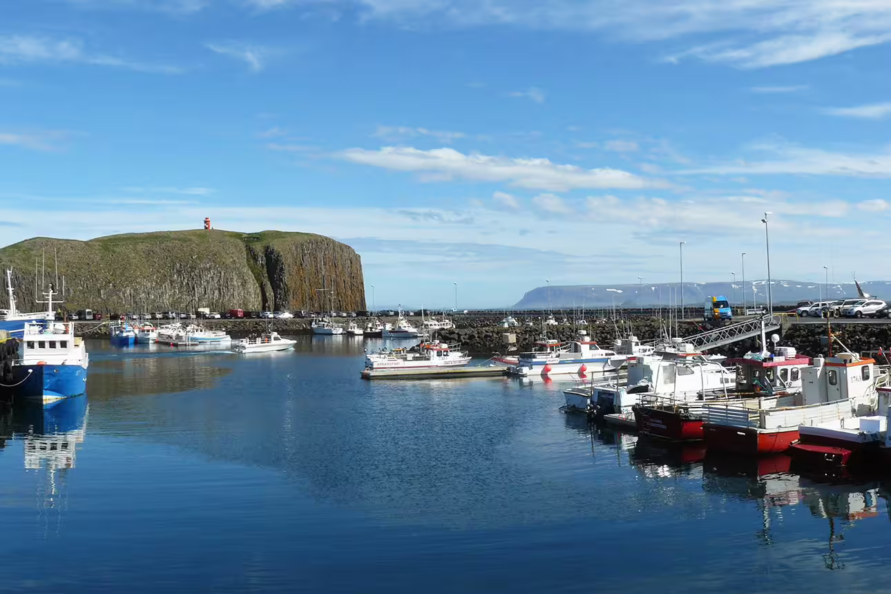 Stykkishólmur harbor with fishing boats and volcanic rock island lighthouse on Snæfellsnes Peninsula Iceland