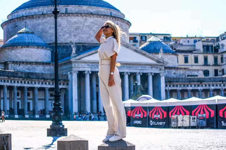 Stylish woman posing on pedestal in Naples' Piazza del Plebiscito for a private photography session.