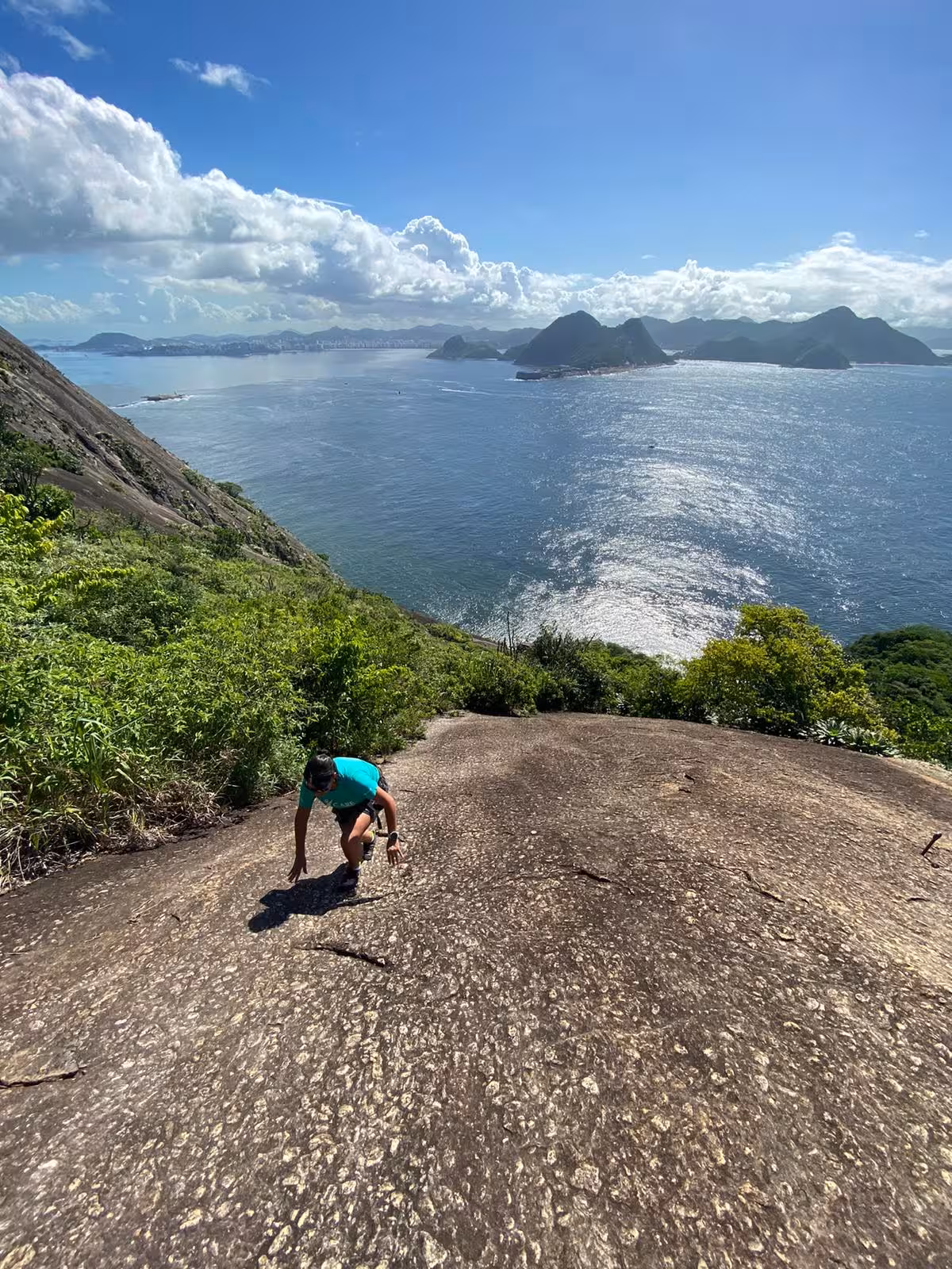 Adventurer climbing Sugarloaf Rock with panoramic ocean backdrop, perfect for rock climbing at any skill level.