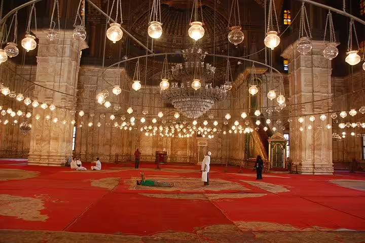 Inside Sultan Hassan Mosque with chandeliers and red carpets on Islamic Cairo private tour with lunch