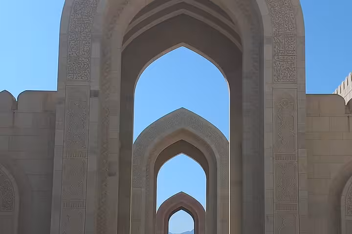 Ornate stone archways at Sultan Qaboos Grand Mosque in Muscat, a highlight of the private half-day Muscat and Bimmah Sinkhole tour