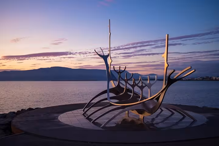 Sun Voyager steel Viking ship sculpture on Reykjavik waterfront at sunset with mountains in background