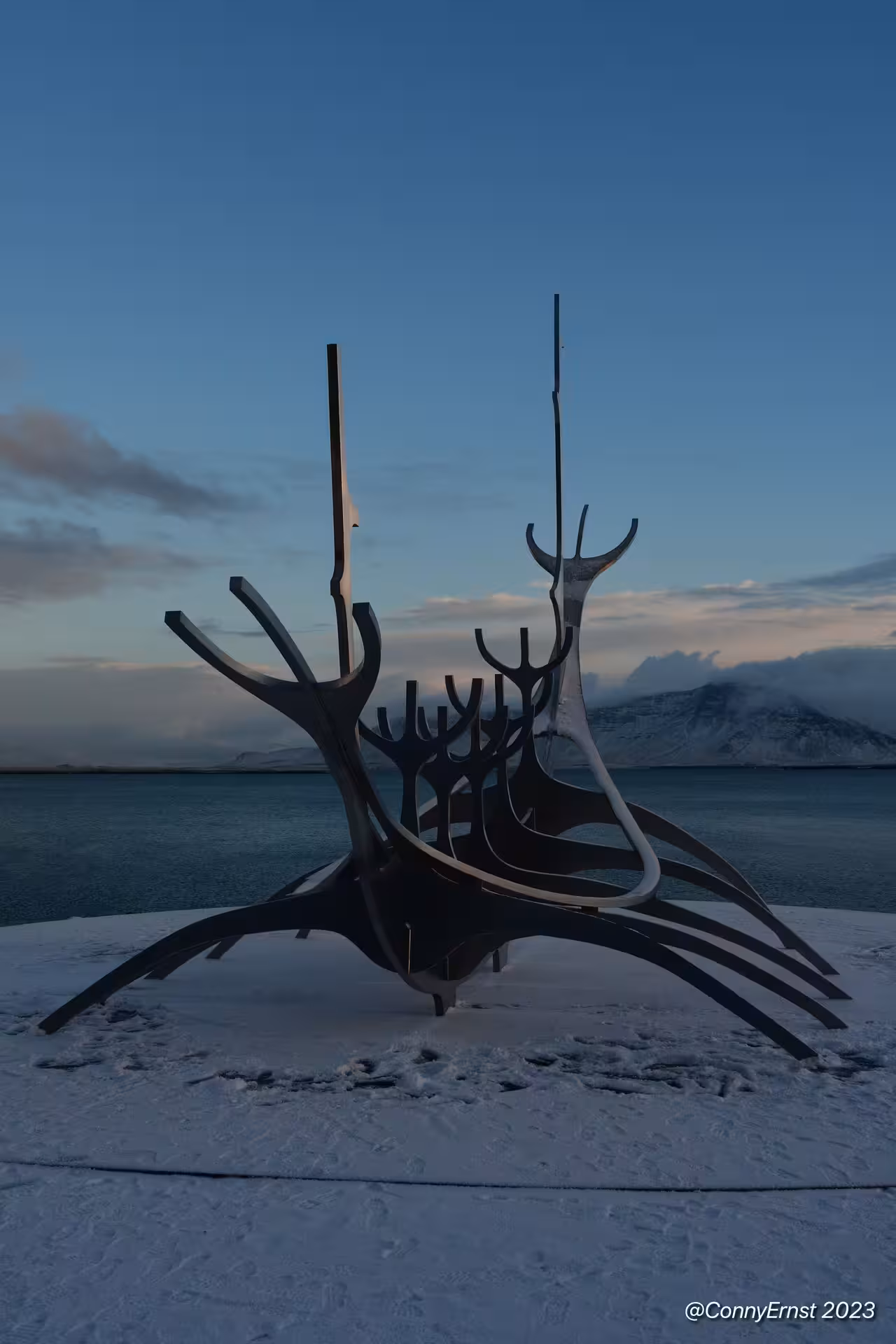 Sun Voyager Viking ship sculpture in snow by Reykjavik waterfront at dusk