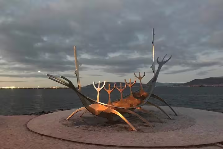 Sun Voyager Viking ship sculpture on Reykjavik waterfront at dusk with cloudy sky