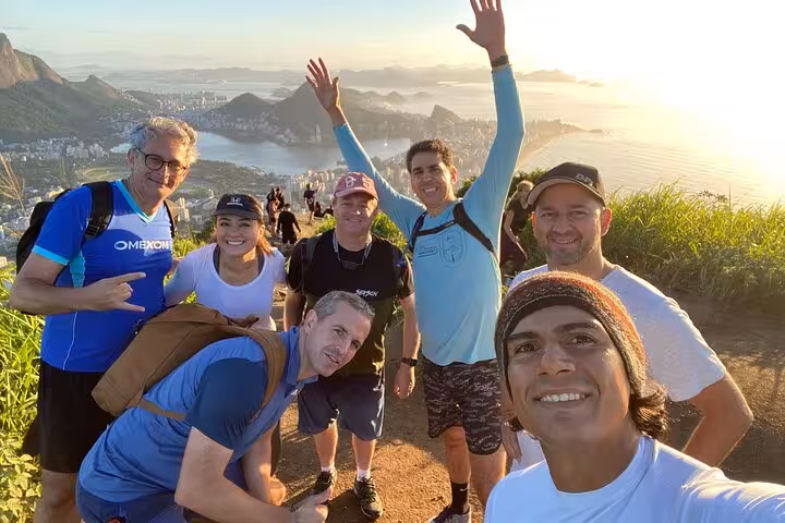 Group enjoying sunrise hike at Two Brothers Mountain with panoramic views of Rio de Janeiro.