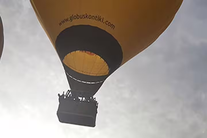 A vibrant hot air balloon soars against the sky during a thrilling Igualada balloon riding tour.