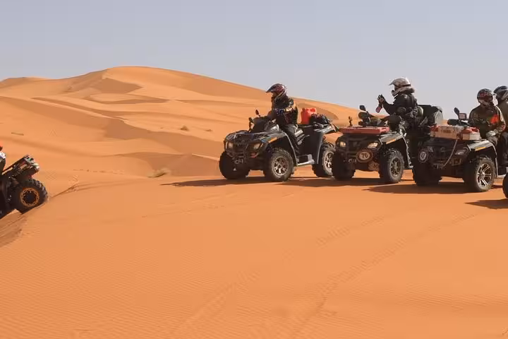 Riders on quad bikes crossing sand dunes near Hurghada at sunset, 5-hour ATV buggy jeep desert safari