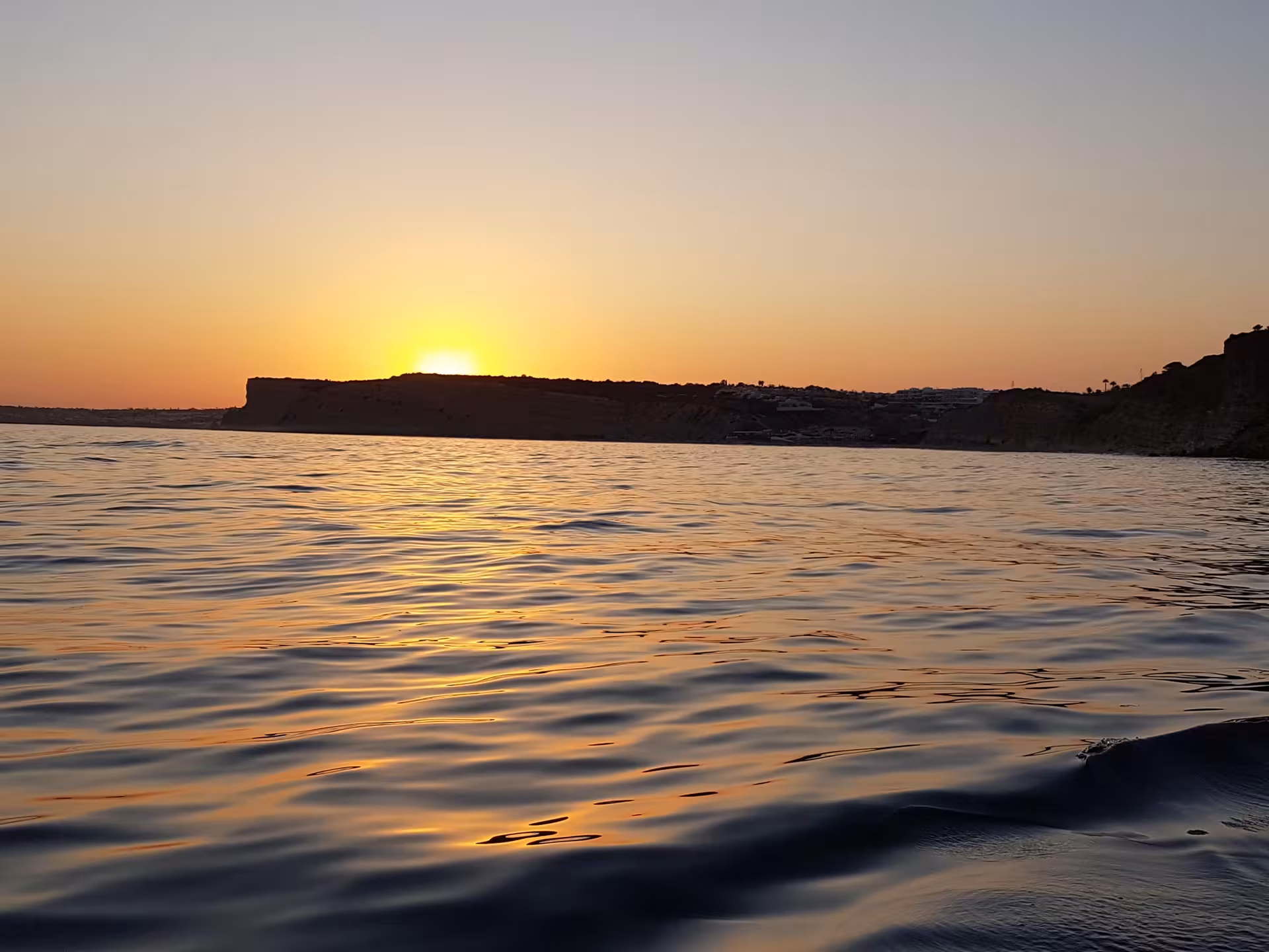 Golden Algarve sunset over the Atlantic Ocean near Ponta da Piedade, seen from a tranquil Lagos coastal boat tour