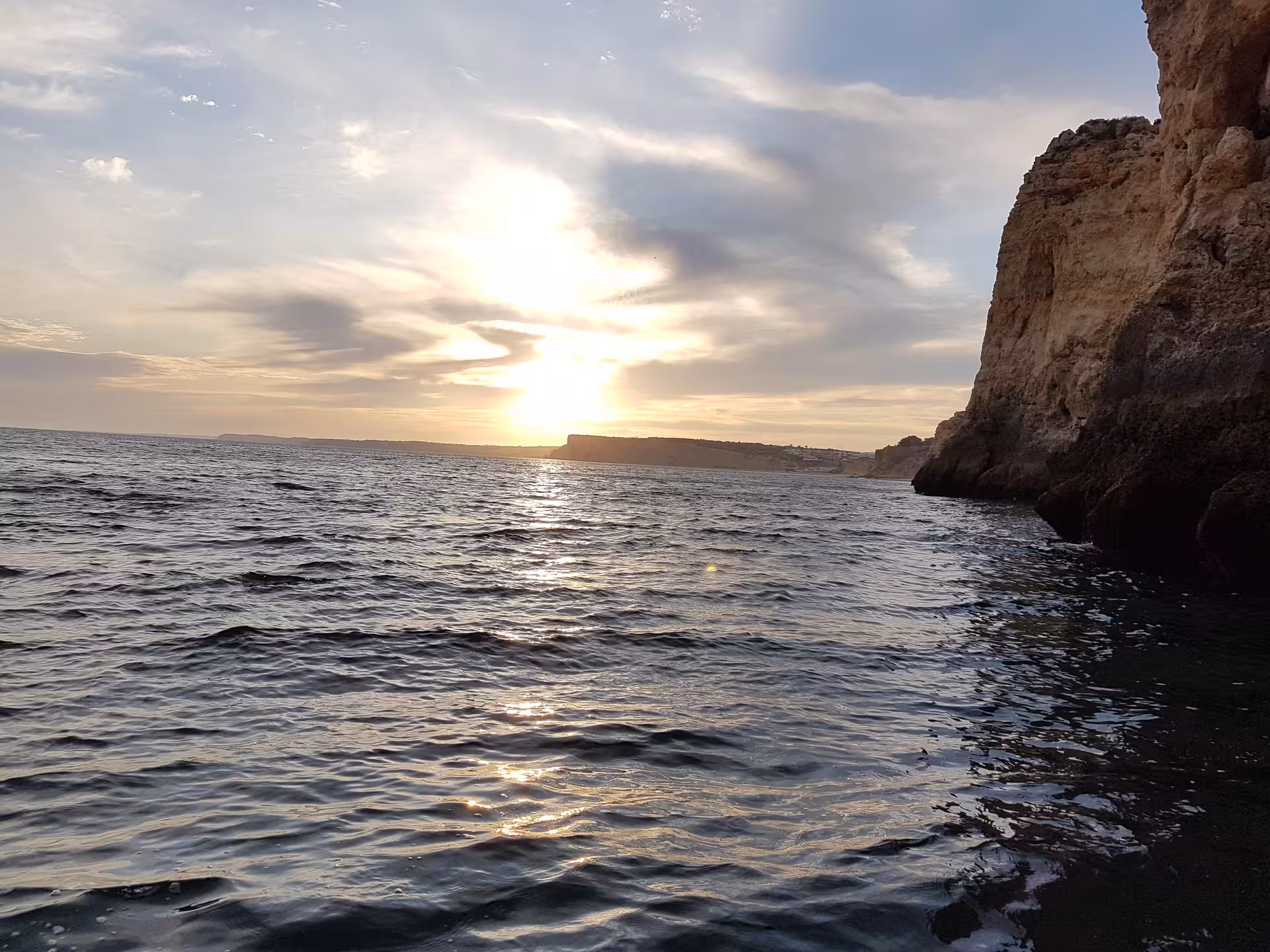 Golden sunset over the Atlantic Ocean by Ponta da Piedade cliffs in Lagos, Portugal, seen from a peaceful boat tour
