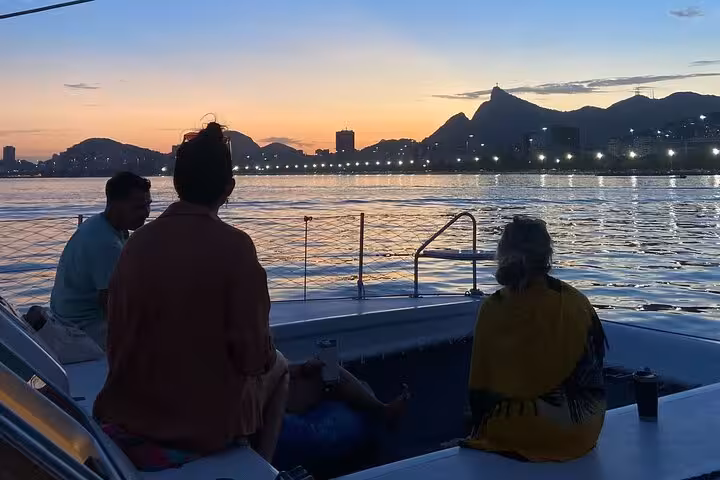 Sunset catamaran cruise in Rio de Janeiro with guests relaxing onboard, open bar and skyline views