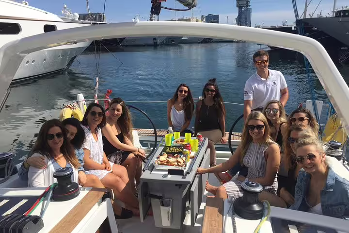 Group enjoying a sunny afternoon on a luxurious sailboat during an exclusive sunset cruise from Barcelona's vibrant harbor.