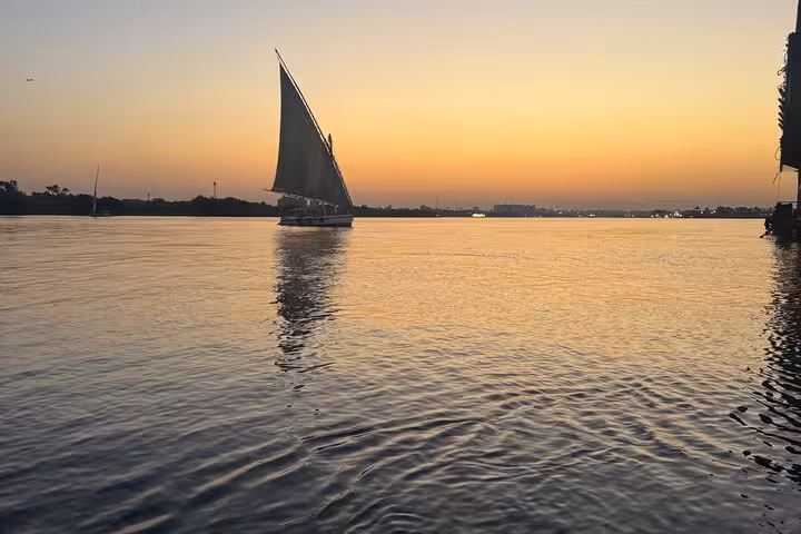 Sunset felucca sailboat gliding on the Nile River in Cairo, relaxing ride with hotel pickup included