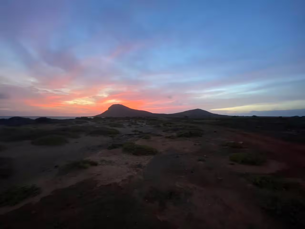 Sunset hike to Mount Lion with volcanic hills silhouetted under colorful skies on a guided evening trek