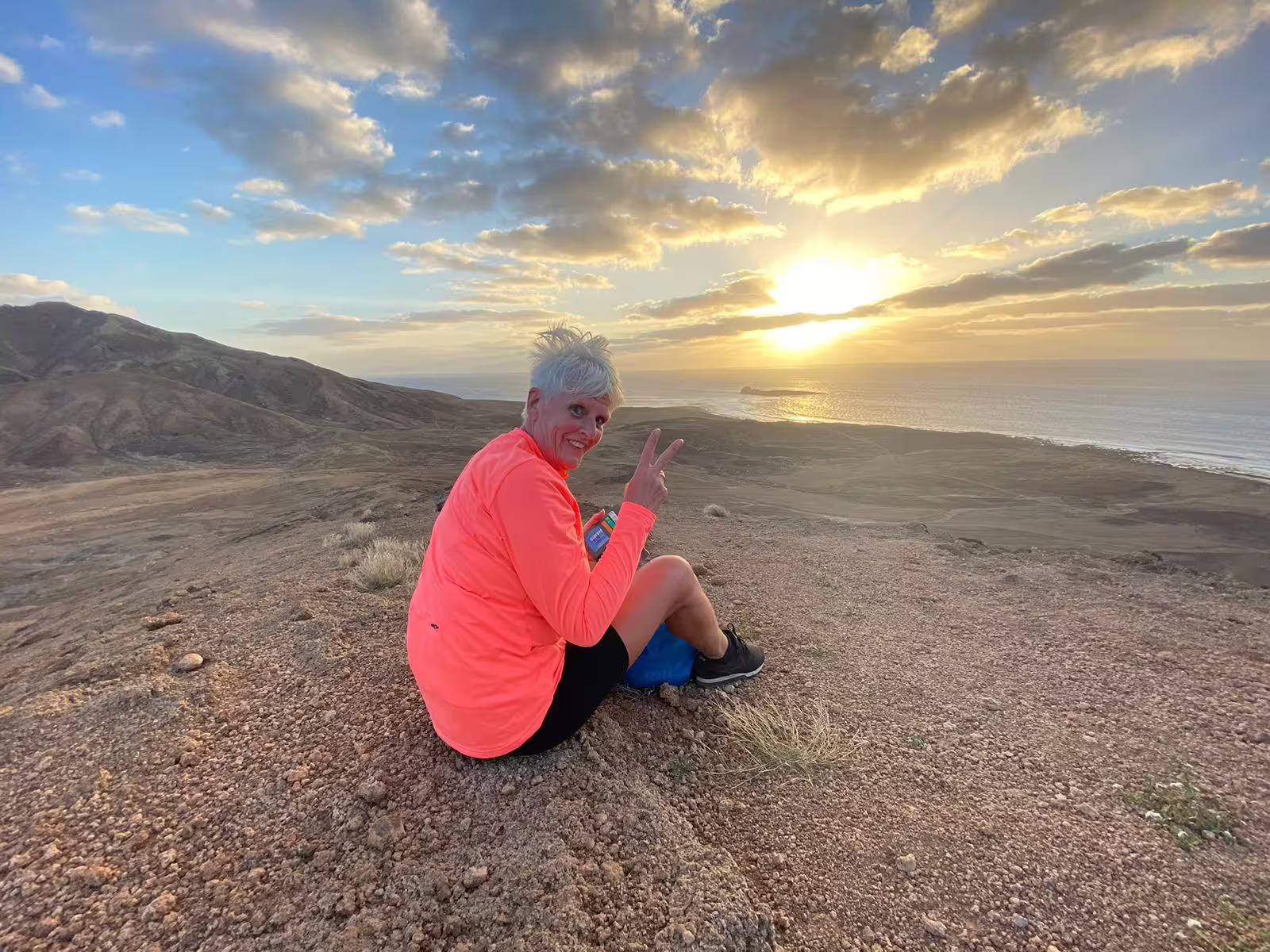 Traveler resting on Mount Lion at golden hour, enjoying coastal views on a guided sunset hiking tour