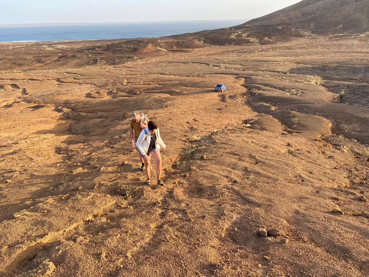 Hikers climbing rugged Mount Lion trail at golden hour with ocean views, guided sunset hiking tour adventure