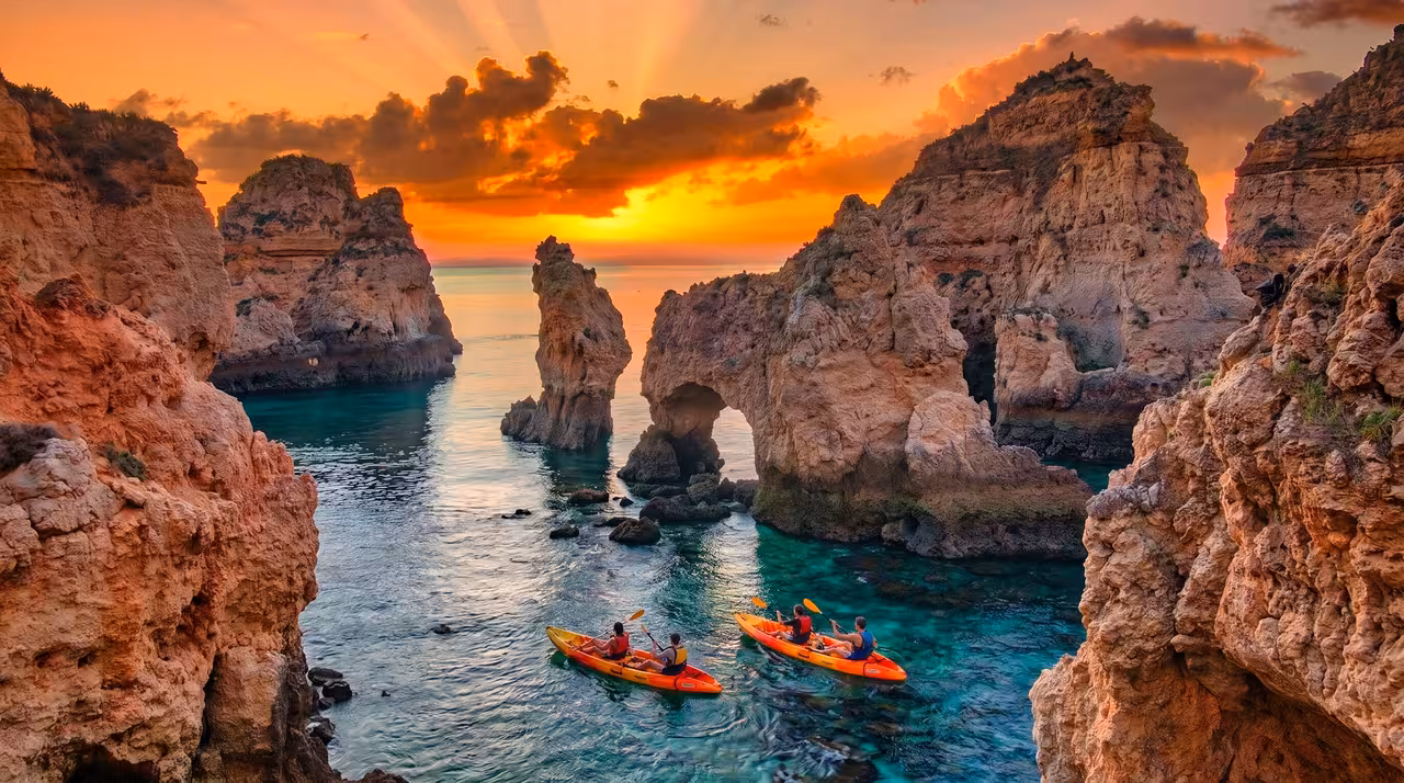 Sunset kayak tour at Ponta da Piedade Lagos with dramatic orange cliffs and turquoise waters in Algarve Portugal