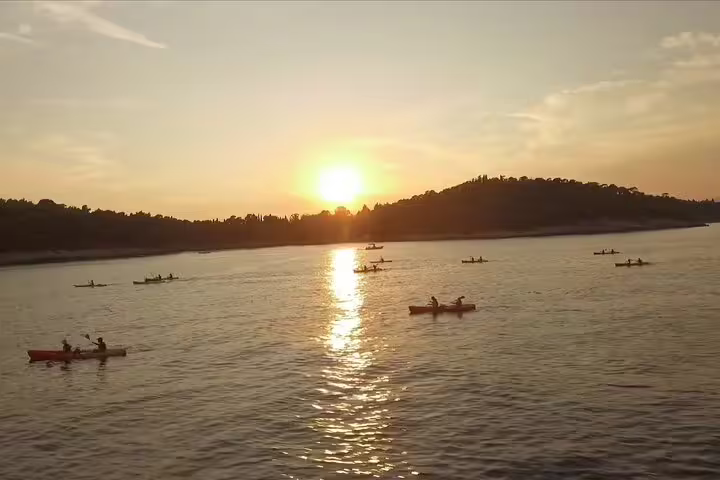 Sunset sea kayaking tour with snorkel stop, calm Adriatic waters and golden light, water and wine served