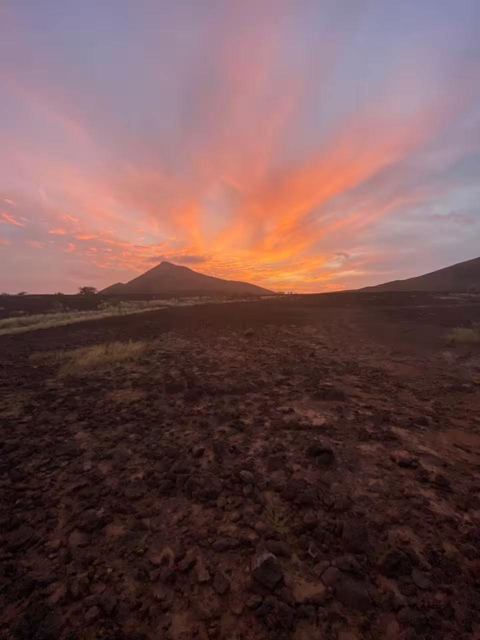 Fiery sunset sky over Mount Lion as hikers cross rocky desert trail on the Sunset Hiking to Mount Lion tour