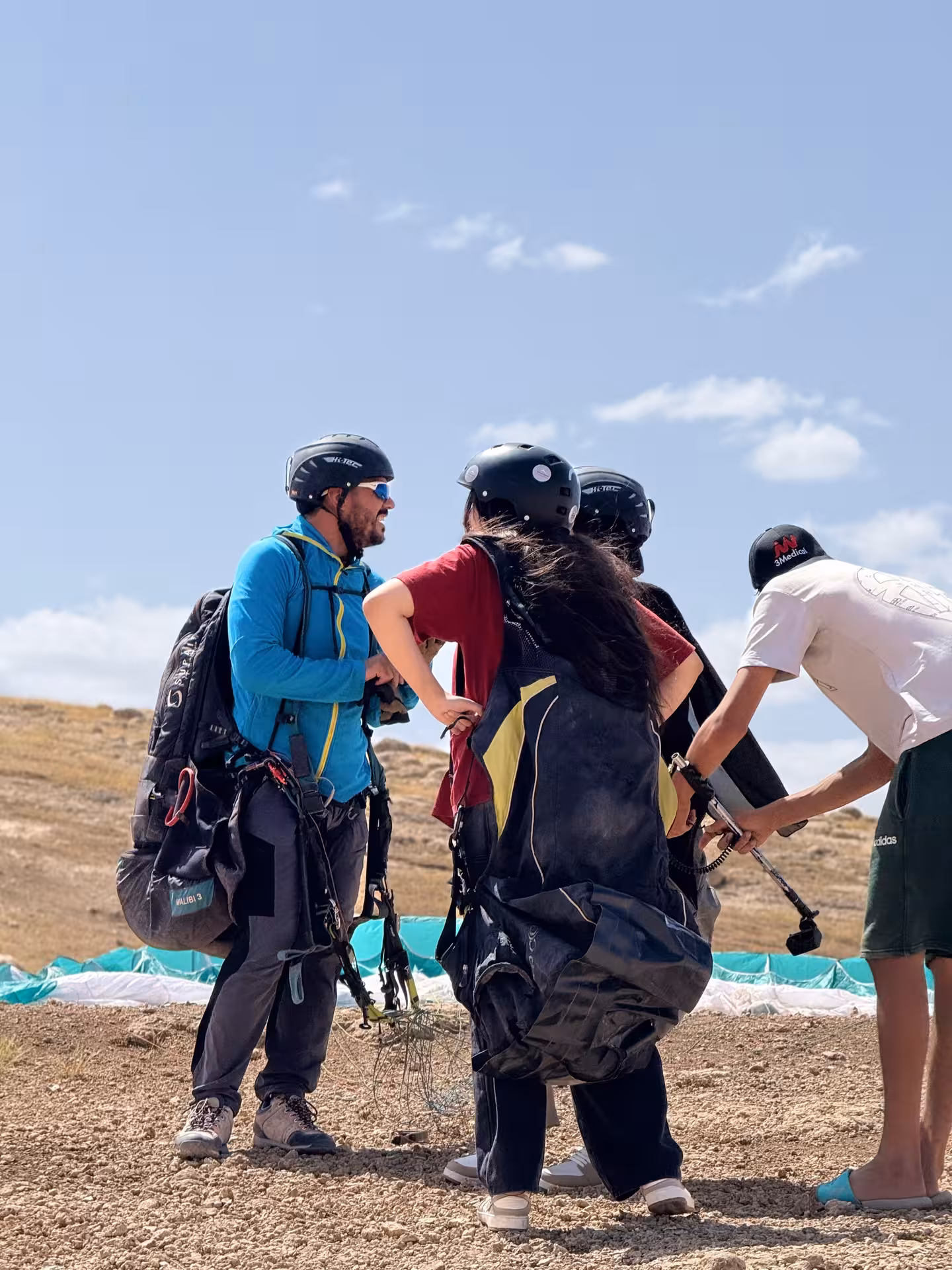 Paragliding team prepares for flight in the Agafay Desert under a clear blue sky near Marrakech.
