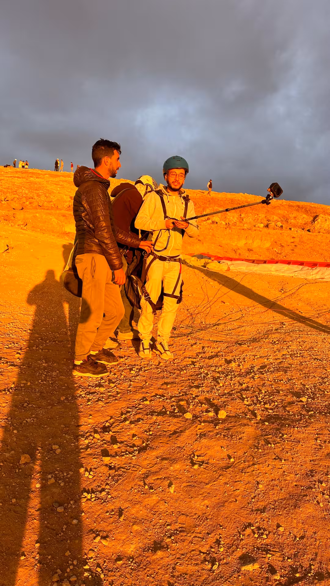 Group of adventurers preparing for sunset paragliding in the Agafay Desert near Marrakech under a clear blue sky.