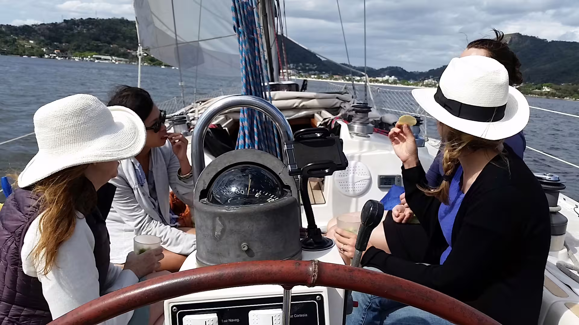 Group of friends enjoying a relaxing sail on Guanabara Bay, Rio de Janeiro, with drinks and snacks.