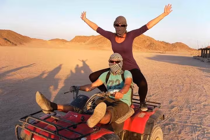 Couple on quad bike at golden hour in Hurghada desert, 3-hour sunset safari from Makadi Bay Soma Bay